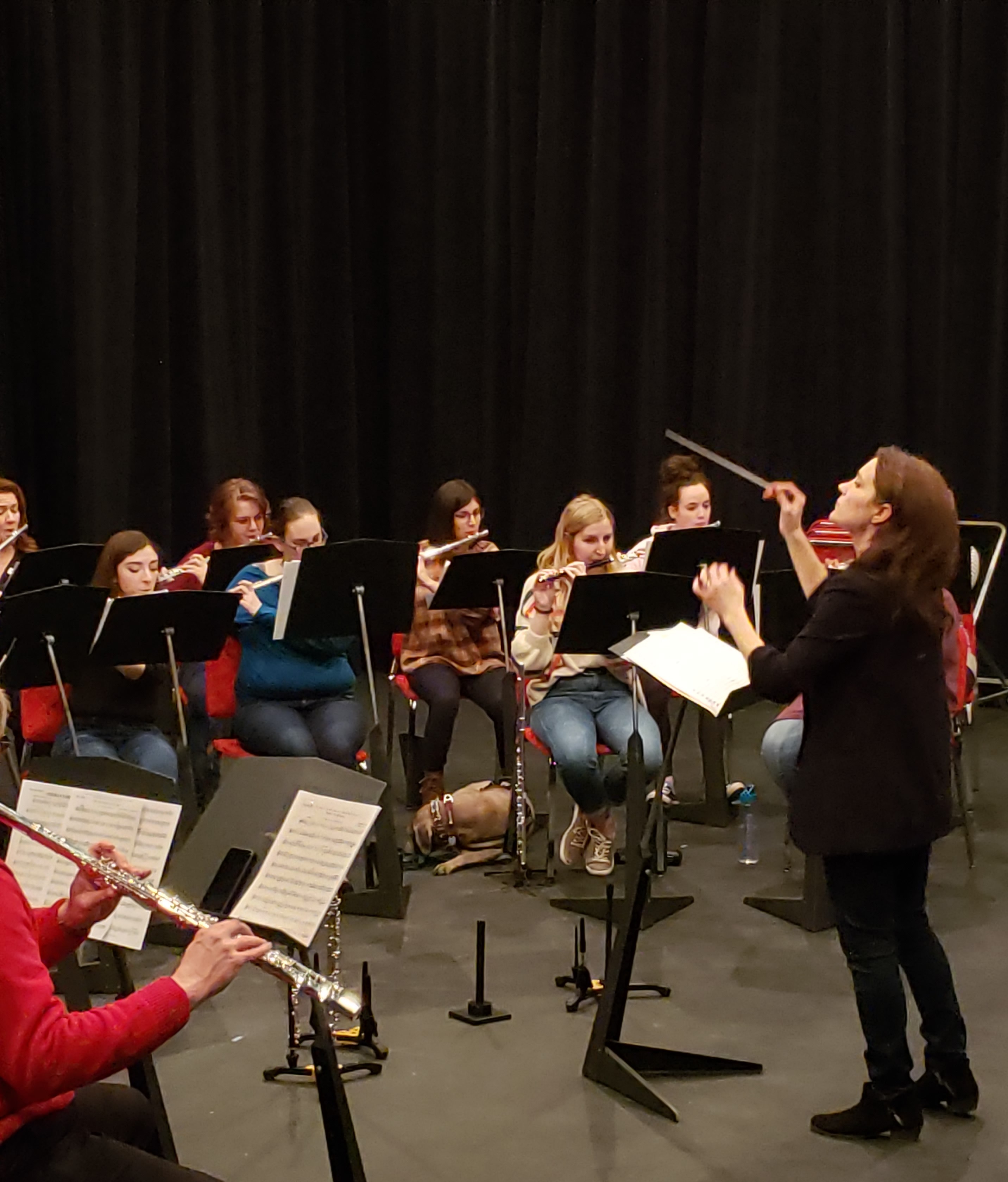 Abigail Walsh conducting a flute ensemble during a community music event.